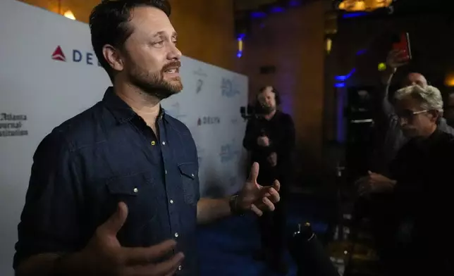 Jason Carter, grandson of President Jimmy Carter, speaks ahead of a "Jimmy Carter 100: A Celebration in Song," concert at the Fox Theatre, Tuesday, Sept. 17, 2024, in Atlanta. (AP Photo/Mike Stewart)