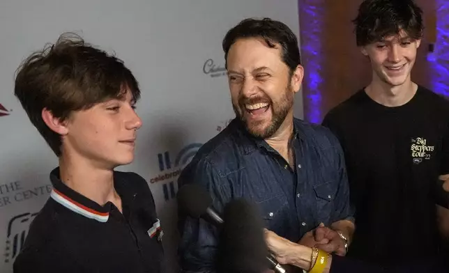 Jason Carter, center, grandson of President Jimmy Carter, with his sons, Henry Lewis Carter, right, and Thomas Clyde Carter, left, attends the "Jimmy Carter 100: A Celebration in Song," concert at the Fox Theatre, Tuesday, Sept. 17, 2024, in Atlanta. Former President Carter turns 100-years old on Oct. 1. (AP Photo/Mike Stewart)