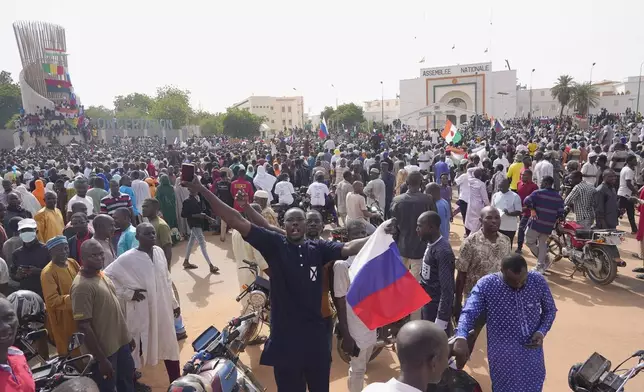 FILE - Nigeriens, some holding Russian flags, participate in a march called by supporters of coup leader Gen. Abdourahmane Tchiani in Niamey, Niger, on July 30, 2023. (AP Photo/Sam Mednick, File)