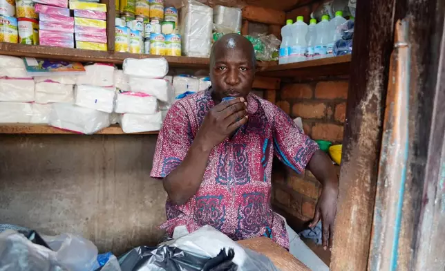 Jean Louis Yet sips from a cup at the market in Bangui, Central African Republic, on March 11, 2024. (AP Photo/Sam Mednick)