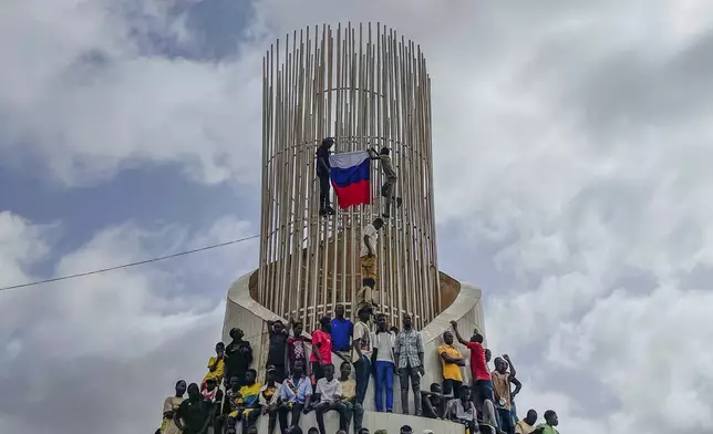 FILE - Supporters of Niger's ruling junta hold a Russian flag at the start of a protest called to fight for the country's freedom and push back against foreign interference in Niamey, Niger, on Aug. 3, 2023. (AP Photo/Sam Mednick, File)