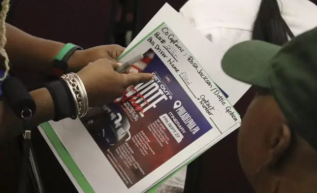 An organizer with the National Action Network signs people in ahead of a Get Out the Vote bus tour toward Philadelphia in the Harlem neighborhood of New York on Friday, Sep. 27, 2024. (AP Photo/Noreen Nasir)