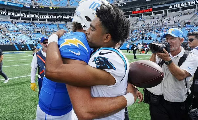 Carolina Panthers quarterback Bryce Young and Los Angeles Chargers quarterback Justin Herbert hug on the field after an NFL football game on Sunday, Sept. 15, 2024, in Charlotte, N.C. (AP Photo/Rusty Jones)