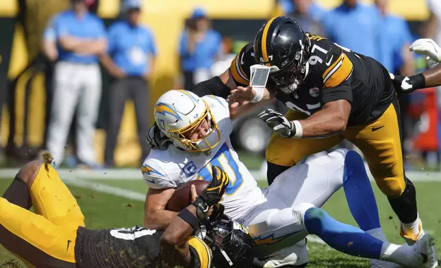 Los Angeles Chargers quarterback Justin Herbert (10) is sacked by Pittsburgh Steelers linebacker Elandon Roberts, bottom left, during the second half of an NFL football game, Sunday, Sept. 22, 2024, in Pittsburgh. (AP Photo/Gene J. Puskar)