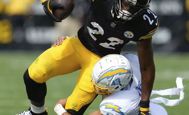 Pittsburgh Steelers running back Najee Harris (22) is tackled by Los Angeles Chargers linebacker Troy Dye, bottom, during the first half of an NFL football game, Sunday, Sept. 22, 2024, in Pittsburgh. (AP Photo/Gene J. Puskar)