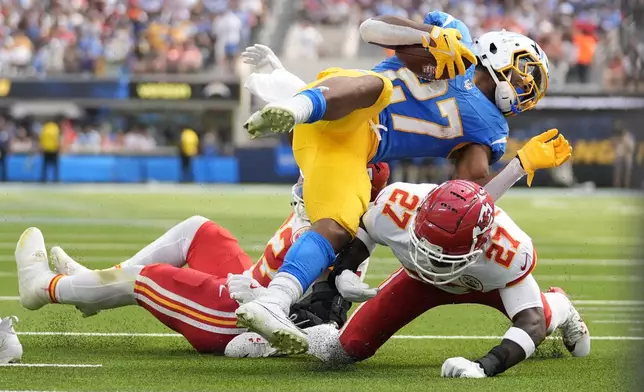 Los Angeles Chargers running back J.K. Dobbins, top, is stopped by Kansas City Chiefs defensive back Chamarri Conner, bottom, during the first half of an NFL football game Sunday, Sept. 29, 2024, in Inglewood, Calif. (AP Photo/Ashley Landis)