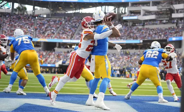 Los Angeles Chargers quarterback Justin Herbert throws under pressure from Kansas City Chiefs cornerback Trent McDuffie (22) during the first half of an NFL football game Sunday, Sept. 29, 2024, in Inglewood, Calif. (AP Photo/Ashley Landis)