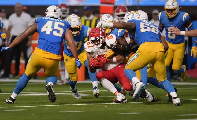 Kansas City Chiefs tight end Travis Kelce (87) catches a pass as a host of Los Angeles Chargers defend during the second half of an NFL football game Sunday, Sept. 29, 2024, in Inglewood, Calif. (AP Photo/Marcio Jose Sanchez)