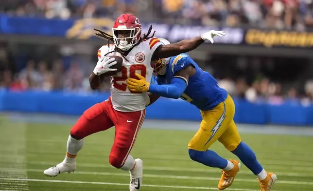 Kansas City Chiefs running back Kareem Hunt (29) runs with the ball as Los Angeles Chargers linebacker Daiyan Henley defends during the second half of an NFL football game Sunday, Sept. 29, 2024, in Inglewood, Calif. (AP Photo/Marcio Jose Sanchez)