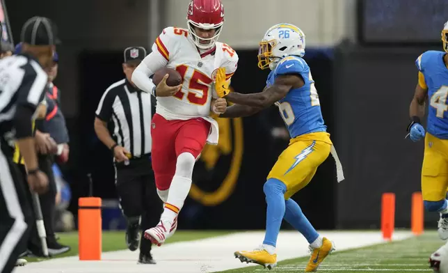 Kansas City Chiefs quarterback Patrick Mahomes (15) is pushed out of bounds by Los Angeles Chargers cornerback Asante Samuel Jr. (26) during the second half of an NFL football game Sunday, Sept. 29, 2024, in Inglewood, Calif. (AP Photo/Ashley Landis)