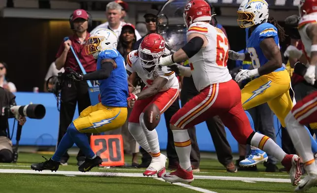 Los Angeles Chargers cornerback Kristian Fulton, left, fumbles the ball out of bounds after intercepting a pass as Kansas City Chiefs wide receiver Rashee Rice (4) defends during the first half of an NFL football game Sunday, Sept. 29, 2024, in Inglewood, Calif. (AP Photo/Marcio Jose Sanchez)