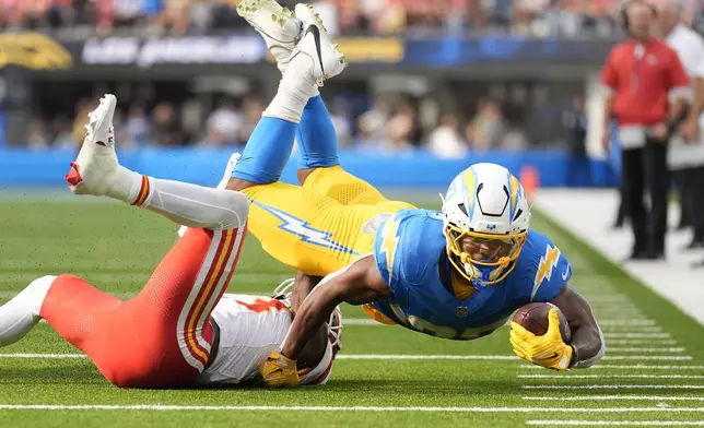 Los Angeles Chargers running back J.K. Dobbins, right, struggles for yardage as Kansas City Chiefs safety Nazeeh Johnson, left, defends during the second half of an NFL football game Sunday, Sept. 29, 2024, in Inglewood, Calif. (AP Photo/Ashley Landis)