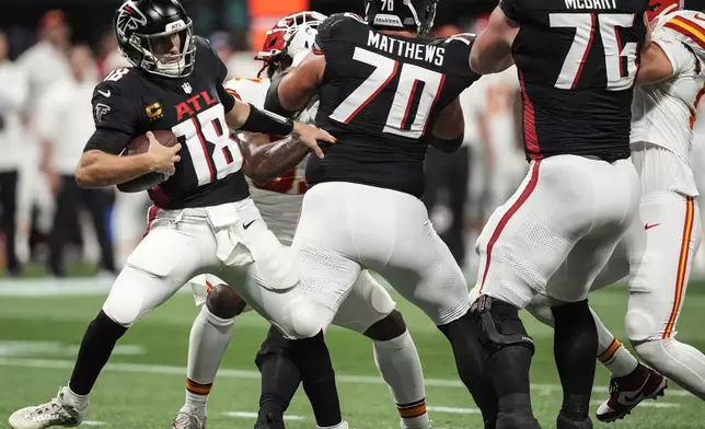 Atlanta Falcons quarterback Kirk Cousins (18) is hit by Atlanta Falcons offensive tackle Jake Matthews (70) against the Kansas City Chiefs during the first half of an NFL football game, Sunday, Sept. 22, 2024, in Atlanta. (AP Photo/Brynn Anderson)