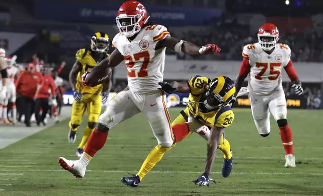 FILE - Kansas City Chiefs running back Kareem Hunt (27) scores a touchdown ahead of Los Angeles Rams free safety Lamarcus Joyner (20) as Chiefs offensive guard Cameron Erving (75) looks on during the first half of an NFL football game, Monday, Nov. 19, 2018, in Los Angeles. (AP Photo/Marcio Jose Sanchez, File)
