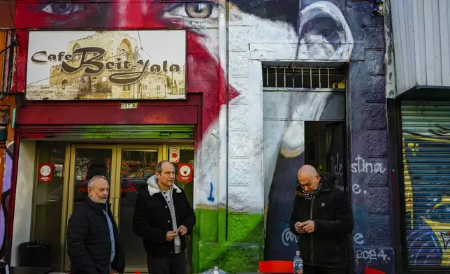 Mauricio Abu Ghosh, former president of Chile's Palestinian Federation, representing Palestinians living in Chile, right, stands outside Cafe Beit-Jala where he met with friends in Santiago, Chile, Monday, Aug. 12, 2024. The Club Palestino soccer club in Chile went professional in 1947 and its appeal stretched to the Middle East, where the descendants of Palestinian refugees in Lebanon and Jordan still congregate in camps and cafes to catch Palestino matches broadcast by satellite network Al Jazeera. (AP Photo/Esteban Felix)