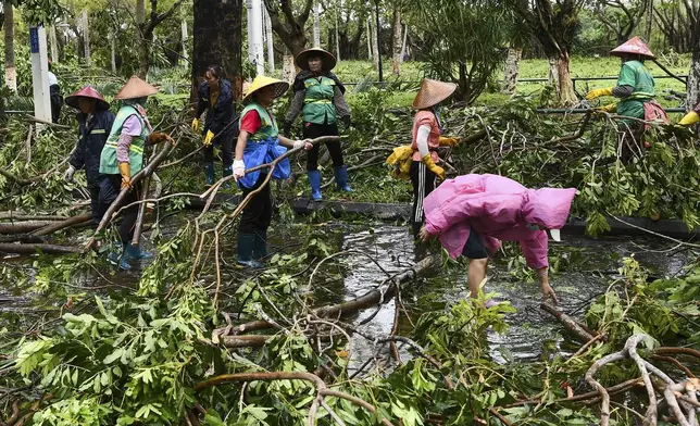 In this photo released by Xinhua News Agency, workers remove fallen tree branches along a street in the aftermath of Typhoon Yagi in Haikou, south China's Hainan Province, Saturday, Sept. 7, 2024. (Yang Guanyu/Xinhua via AP)