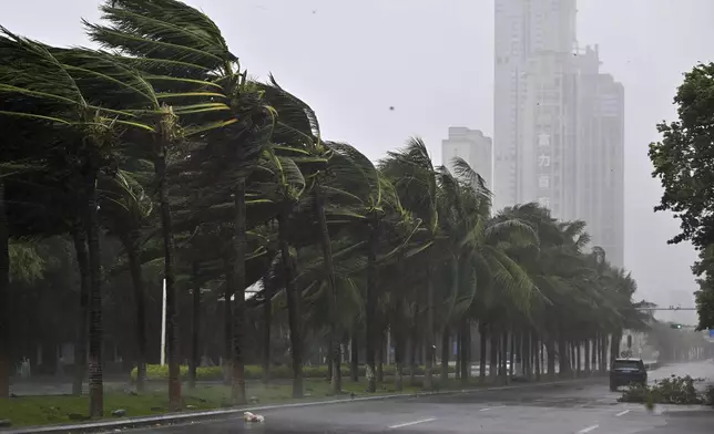 In this photo released by Xinhua News Agency, a vehicle moves past trees along a road in Haikou following the landfall of typhoon Yagi, in south China's Hainan Province, Friday, Sept. 6, 2024. (Guo Cheng/Xinhua via AP)