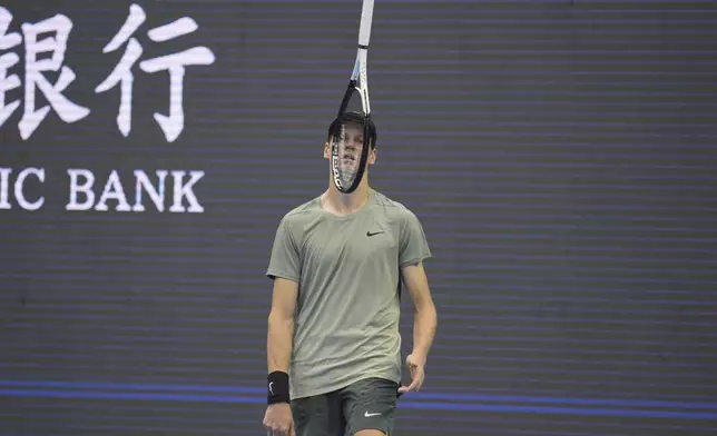 Jannick Sinner of Italy tosses his racket as he waits for play against Roman Safiullin of Russia during the China Open tennis tournament held at the National Tennis Center in Beijing, Saturday, Sept. 28, 2024. (AP Photo/Ng Han Guan)