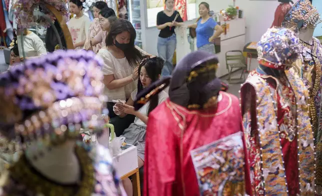 A Chinese girl gets her hair done up at a business building that provides one stop service for the Qing Dynasty traditional look, in Beijing, China, Sunday, July 21, 2024. (AP Photo/Vincent Thian)