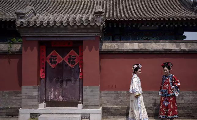 Chinese women dressed in Qing Dynasty attire at the Forbidden city in Beijing, China, Sunday, July 21, 2024. (AP Photo/Vincent Thian)