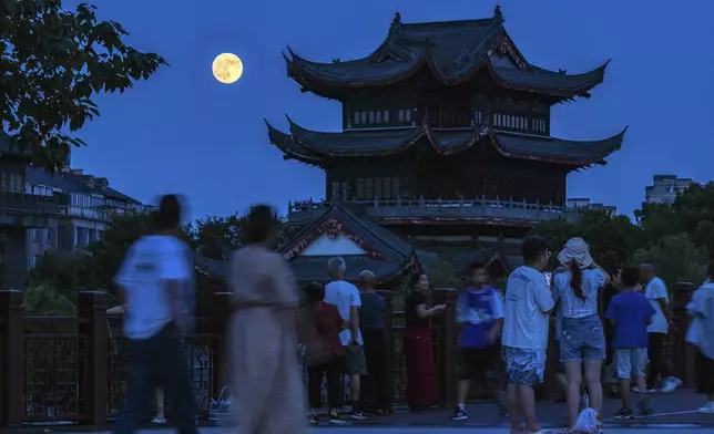 In this photo released by Xinhua News Agency, a full moon rises as visitors tour a scenic area during the Mid-Autumn Festival in Huzhou City in east China's Zhejiang Province, Tuesday, Sept. 17, 2024. (Yi Fan/Xinhua via AP)