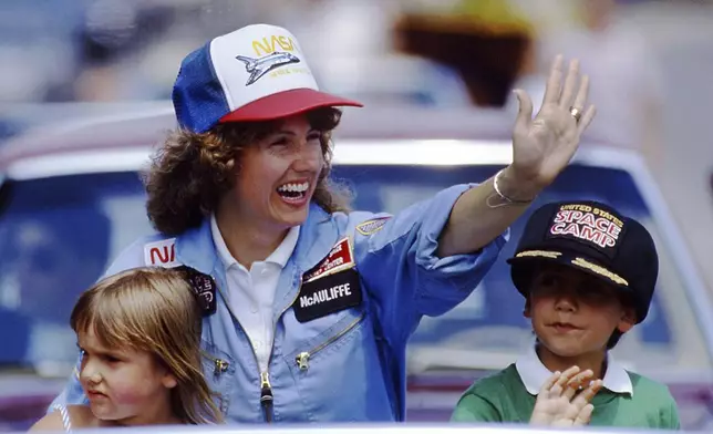 FILE - In this 1985 file photo, high school teacher Christa McAuliffe rides with her children Caroline, left, and Scott during a parade down Main Street in Concord, N.H. (AP Photo/Jim Cole, File)