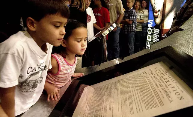 FILE - Conor Park, 8, and his sister Ripley Park, 7, look at an original printed version of the Declaration of Independence at the Capitol in Phoenix, Wednesday, Oct. 8, 2003. (AP Photo/Matt York, File)