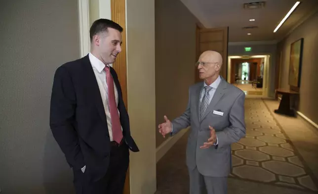 U.S. Marine Capt. Jameson Broggi, left, speaks with Michael Poliakoff, CEO of the American Council of Trustees and Alumni, before a luncheon in Cary, N.C., on Monday, April 29, 2024. With help from ACTA, Broggi has written legislation in two states to require public college students to take a civics class in order to graduate. (AP Photo/Allen G. Breed)