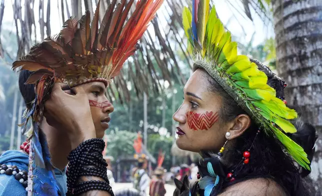 Apolima-Arara Indigenous youth Ozileia Macedo, right, puts face paint on Antonio Acassio Avelino de Oliveira, during the annual celebration recognizing the Ashaninka territory in the Apiwtxa village, Acre state, Brazil, Monday, June 24, 2024. (AP Photo/Jorge Saenz)