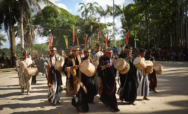 Ashaninka Indigenous musicians from Brazil and Peru perform during the annual celebration recognizing the Ashaninka territory in the Apiwtxa village, Acre state, Brazil, Monday, June 24, 2024. (AP Photo/Jorge Saenz)