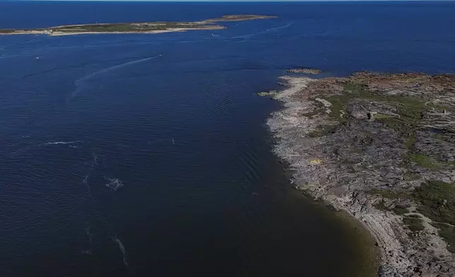 Water from the Churchill River, left, drains into the Hudson Bay, top right, Thursday, Aug. 8, 2024, in Churchill, Canada. (AP Photo/Joshua A. Bickel)