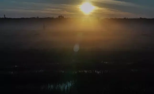 The sun rises over the tundra, Wednesday, Aug. 7, 2024, near Churchill, Manitoba. (AP Photo/Joshua A. Bickel)