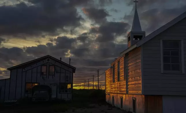 The setting sun illuminates the Anglican Church, Sunday, Aug. 4, 2024, in Churchill, Manitoba. (AP Photo/Joshua A. Bickel)