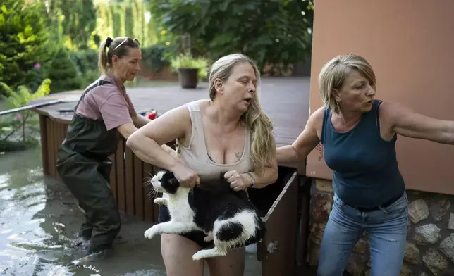 FILE - Women save a cat from floods in Szentendre, near Budapest, Hungary, Sept. 19, 2024. (AP Photo/Denes Erdos)