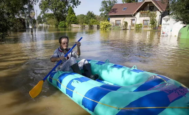 FILE - A resident paddles through a flooded street in Bohumin, Czech Republic, Sept. 17, 2024. (AP Photo/Darko Bandic, File)