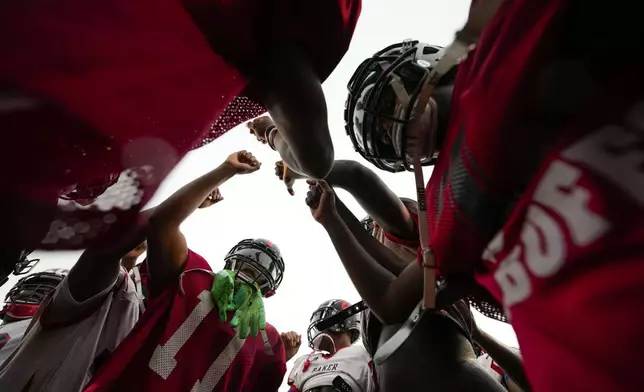 Members of the Baker High football team huddle at practice in Baker, La., Wednesday, Aug. 28, 2024. (AP Photo/Gerald Herbert)