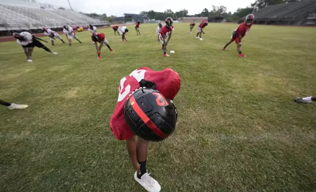 Members of the Baker High football team warm up at practice in Baker, La., Wednesday, Aug. 28, 2024. (AP Photo/Gerald Herbert)