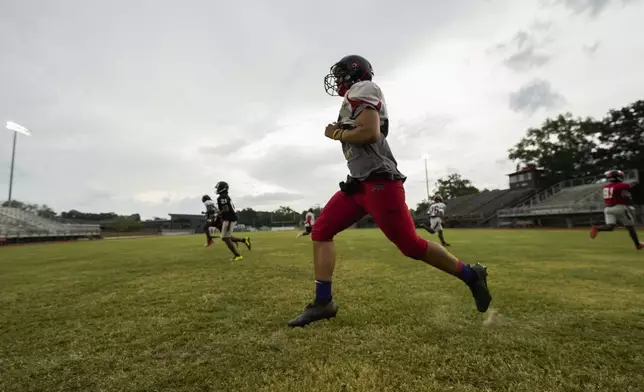 Members of the Baker High football team warm up at practice in Baker, La., Wednesday, Aug. 28, 2024. (AP Photo/Gerald Herbert)