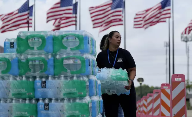 FILE - Staff at Lakewood Church hand out water and operate a cooling station in Houston, July 9, 2024. (AP Photo/Eric Gay, File)