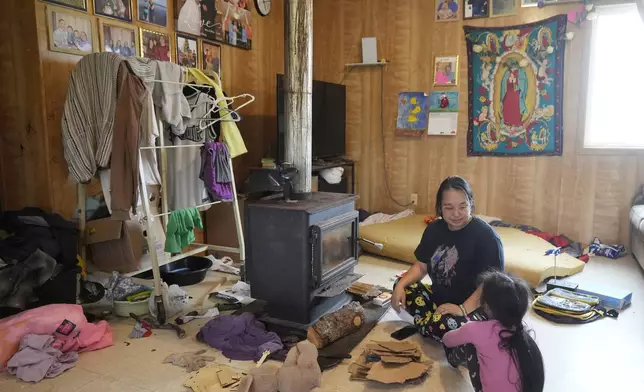 Jennifer sits with her daughter Girlie, 4, at their home on Saturday, Aug. 17, 2024, in Mertarvik, Alaska. (AP Photo/Rick Bowmer)