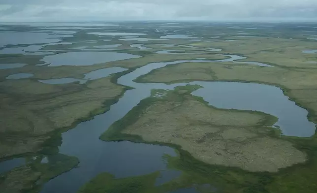 Water and patches of green are visible near Mertarvik, Alaska Tuesday, Aug. 13, 2024. (AP Photo/Rick Bowmer)