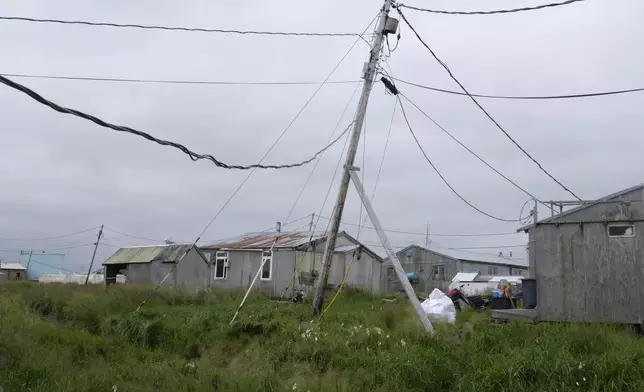 Power poles lean in the village of Newtok, Alaska on Wednesday, Aug. 14, 2024. (AP Photo/Rick Bowmer)