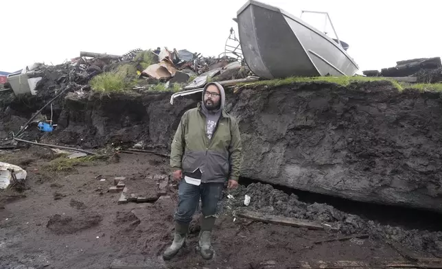 Calvin Tom, the tribal administrator, stands along the eroded coastline in Newtok, Alaska on Friday, Aug. 16, 2024. (AP Photo/Rick Bowmer)