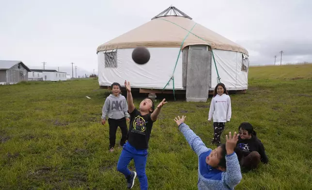 Children play along the tundra on Friday, Aug. 16, 2024, in Mertarvik, Alaska. (AP Photo/Rick Bowmer)