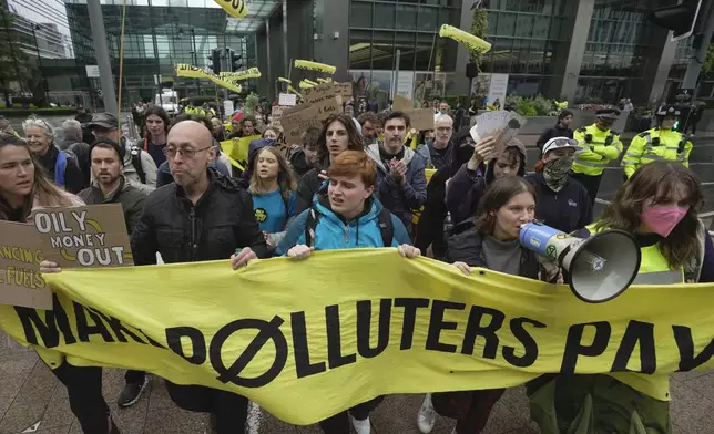 FILE - Environmental activists including Greta Thunberg, center left, marches with other demonstrators during the Oily Money Out protest at Canary Wharf, in London, Oct. 19, 2023. (AP Photo/Kin Cheung, File)