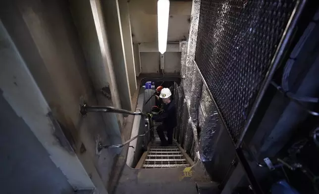 Abigail Jablansky, head of project management, walks down the stairs on the NH3 Kraken, a tugboat powered by ammonia, Friday, Sept. 13, 2024, in Kingston, N.Y. (AP Photo/Alyssa Goodman)