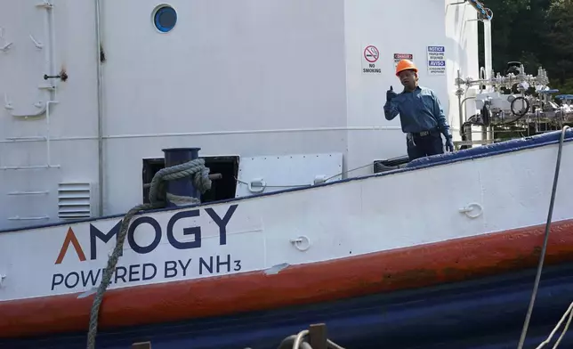 Worker gestures from the NH3 Kraken, a tugboat powered by ammonia, Friday, Sept. 13, 2024, in Kingston, N.Y. (AP Photo/Alyssa Goodman)