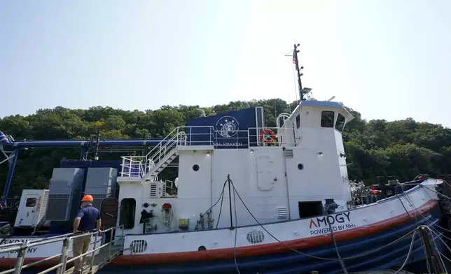 A worker stands near the NH3 Kraken, a tugboat powered by ammonia, on Friday, Sept. 13, 2024, in Kingston, N.Y. (AP Photo/Alyssa Goodman)