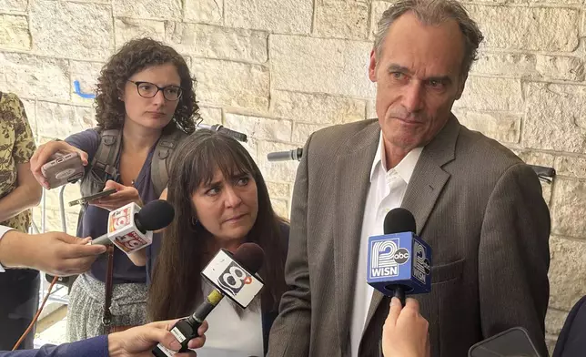 Former University of Wisconsin-La Crosse Chancellor Joe Gow, right, and his wife, Carmen Wilson, center, take questions after a hearing before a committee that will determine whether he can teach after being fired as the campus leader for making pornographic videos, Friday, Sept. 20, 2024, in Madison, Wis. (AP Photo/Scott Bauer)