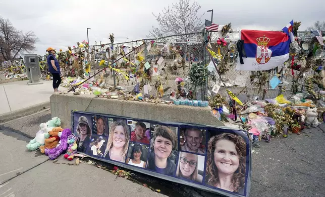 FILE - Pictures of the 10 victims of a mass shooting in a King Soopers grocery store are posted on a cement barrier outside the supermarket in Boulder, Colo., on April 23, 2021. (AP Photo/David Zalubowski, File)